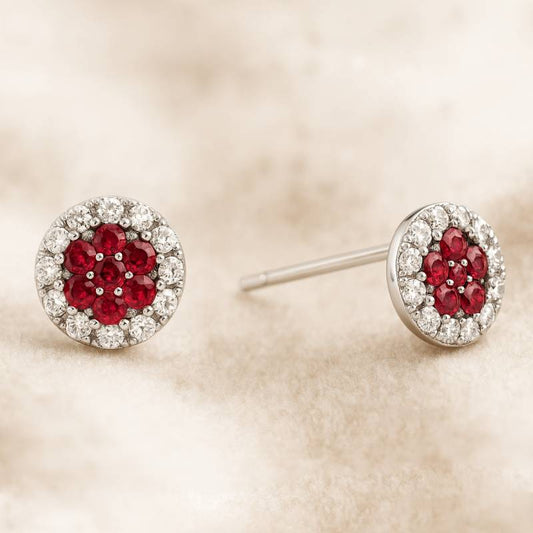 Pair of earrings with red gemstones and diamond-like stones on a beige background