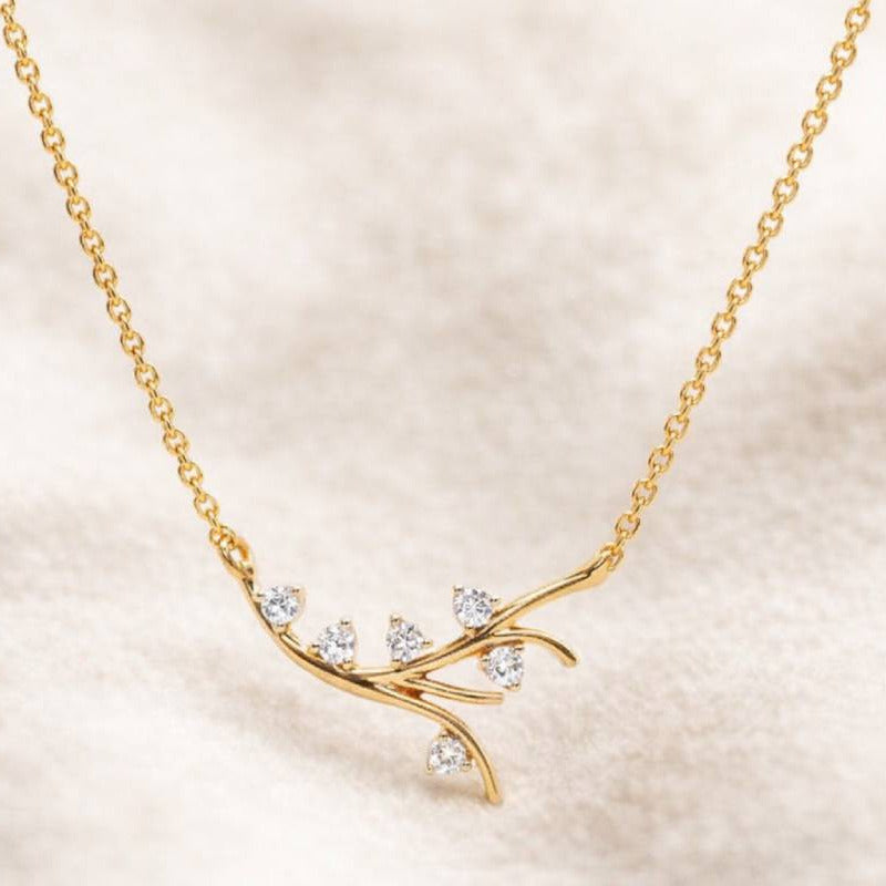 Gold necklace with diamond-like stones on a beige background