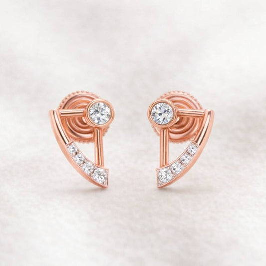 Rose gold earrings with clear gemstones on a light pink background