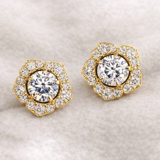 Pair of gold and diamond earrings on a light background