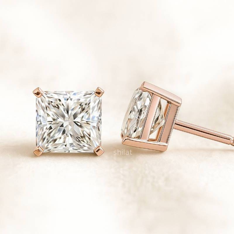 Rose gold diamond earrings on a light beige background