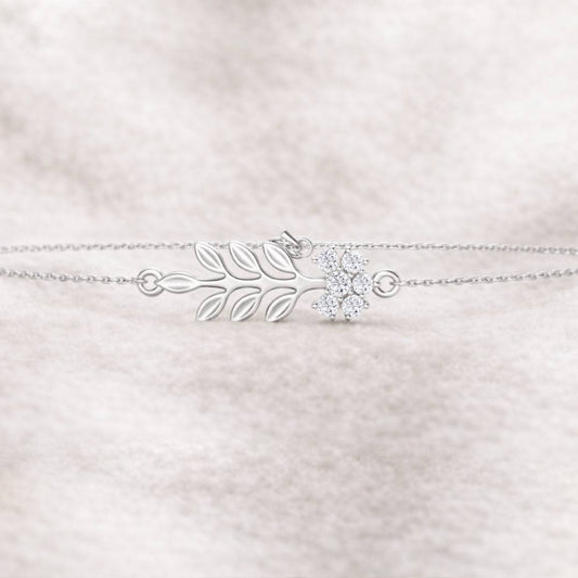 bracelet with leaf design and clear gemstone on a light pink textured background