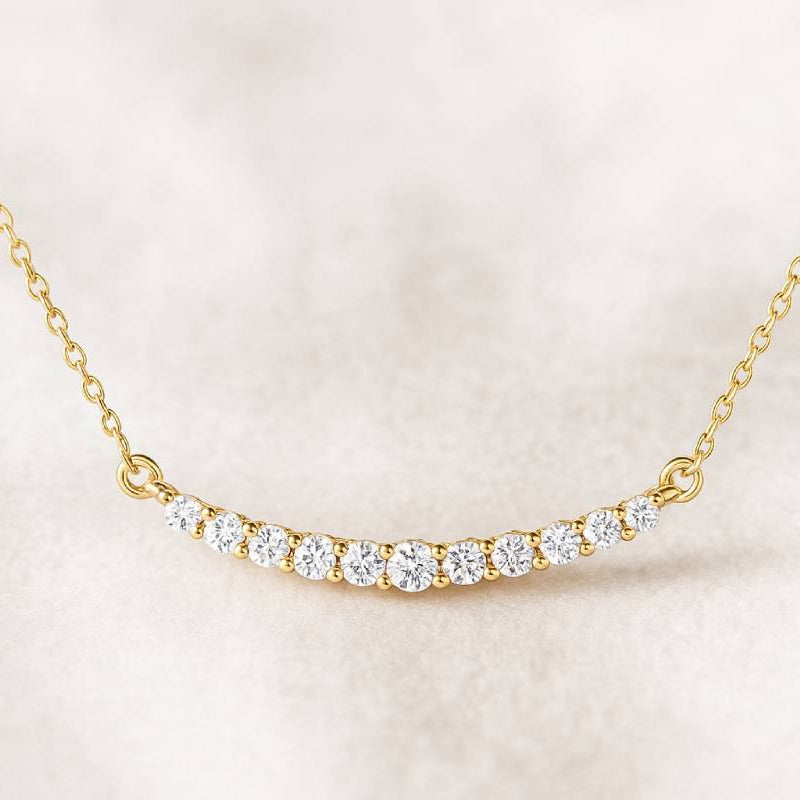 Gold necklace with diamonds on a light pink background