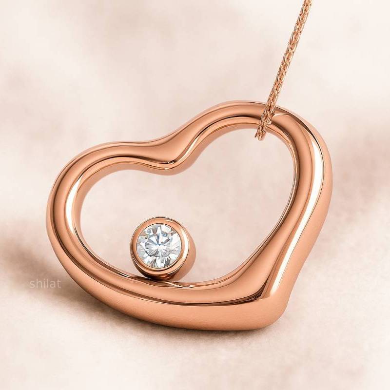 Rose gold heart-shaped pendant with a diamond on a light pink background