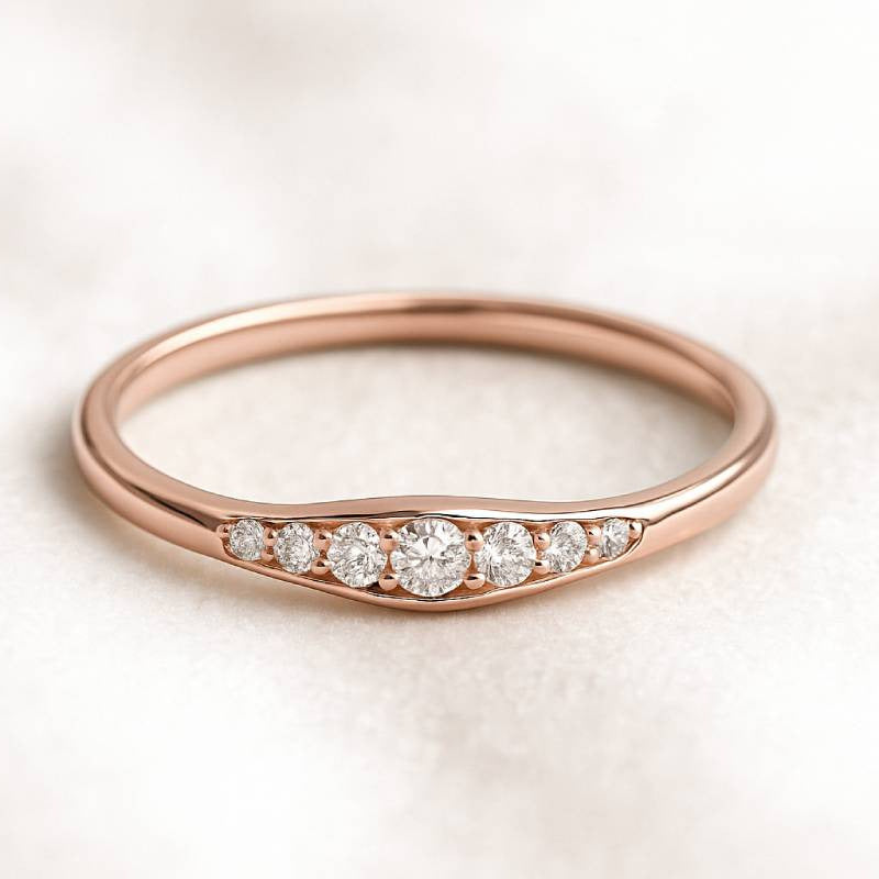 Rose gold ring with diamonds on a light background