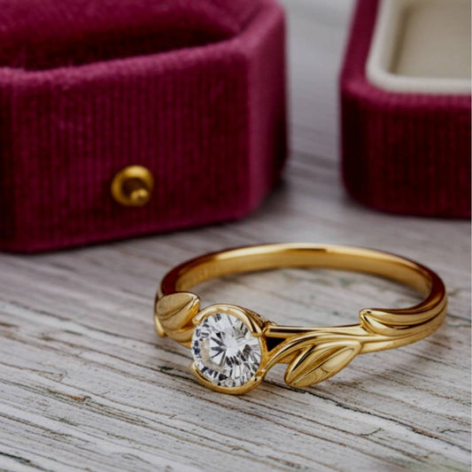 Gold ring with a diamond on a wooden surface with red velvet jewelry box in the background