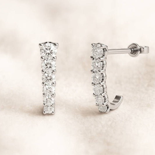 Pair of diamond earrings on a soft beige background