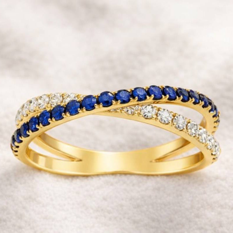 Gold ring with blue gemstones on a light background