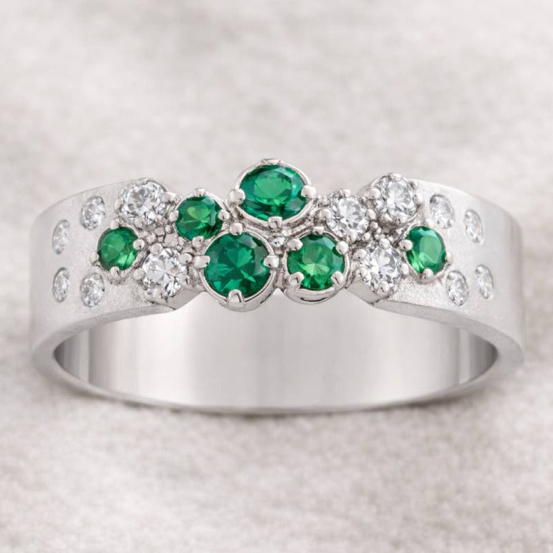 ring with green gemstones on a light gray background