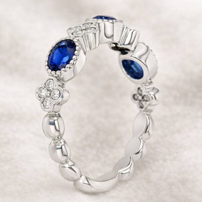 gold ring with blue gemstones on a light gray background