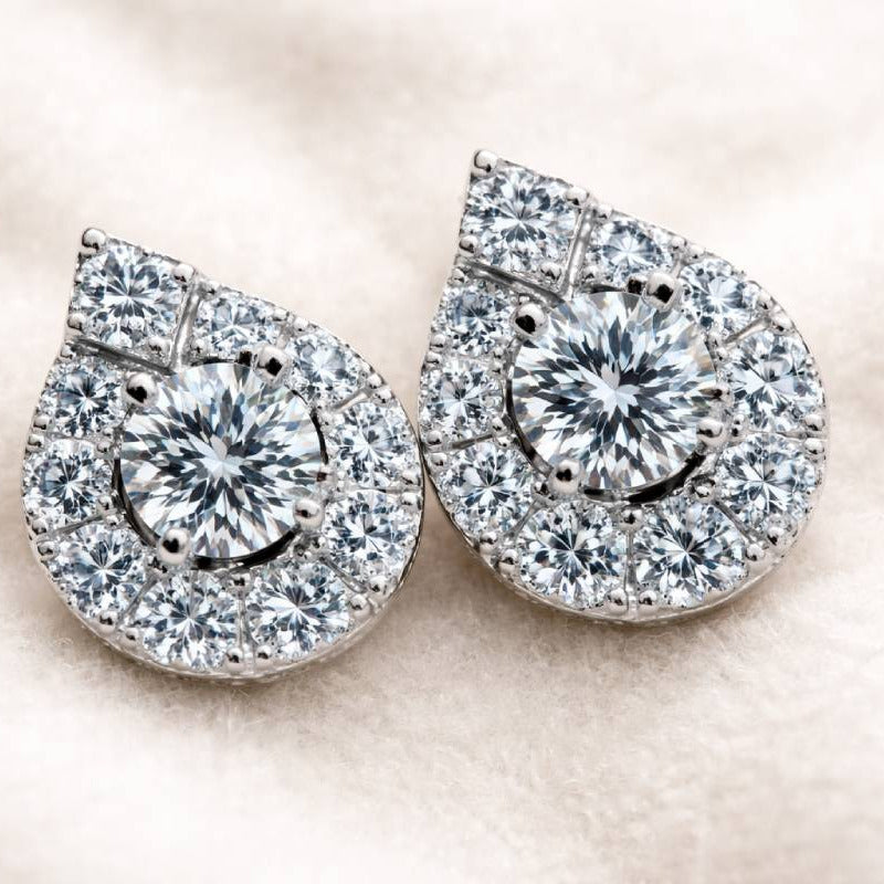 Pair of diamond earrings with a smiley face design on a light background