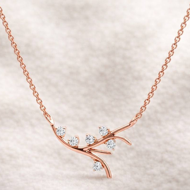 Rose gold necklace with diamond accents on a soft beige background