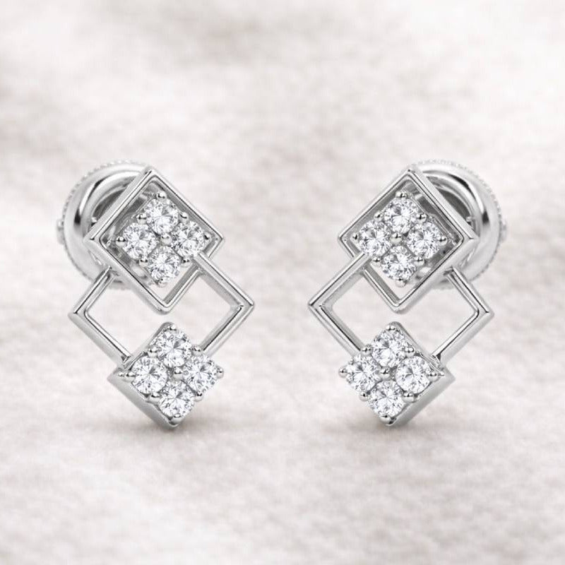 Pair of earrings with diamond-like stones on a light fabric background