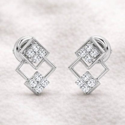 Pair of earrings with diamond-like stones on a light fabric background