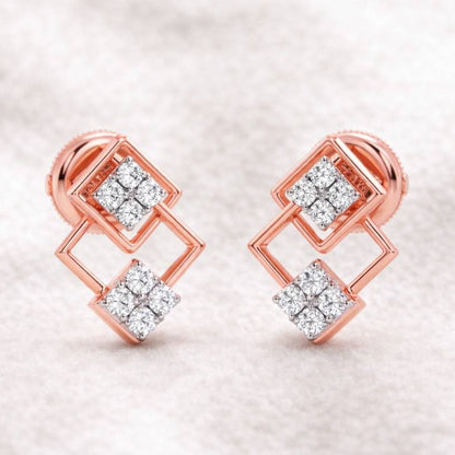 Rose gold earrings with diamond accents on a soft fabric background