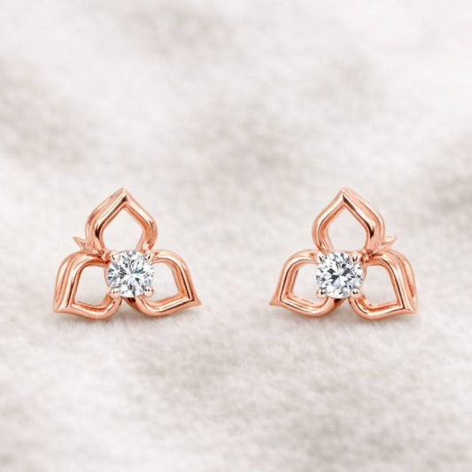 Rose gold earrings with clear gemstones on a soft beige background