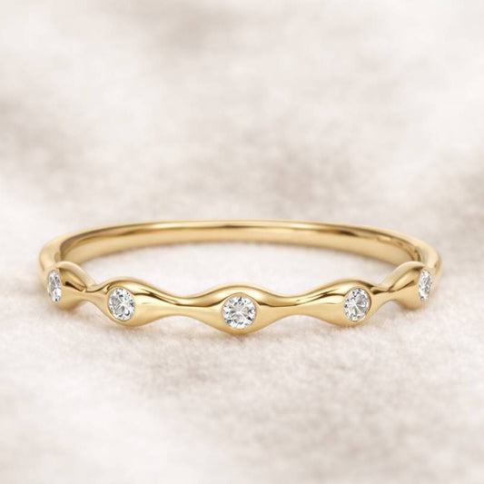 Gold ring with small diamonds on a soft beige background
