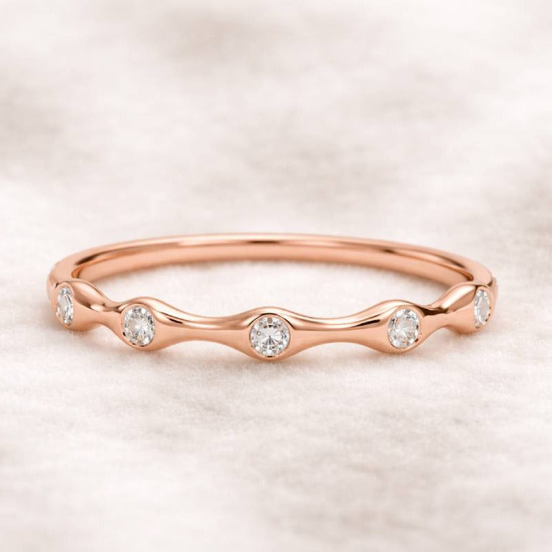 Rose gold ring with diamonds on a soft pink background