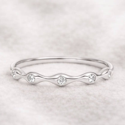 ring with small diamonds on a light gray background
