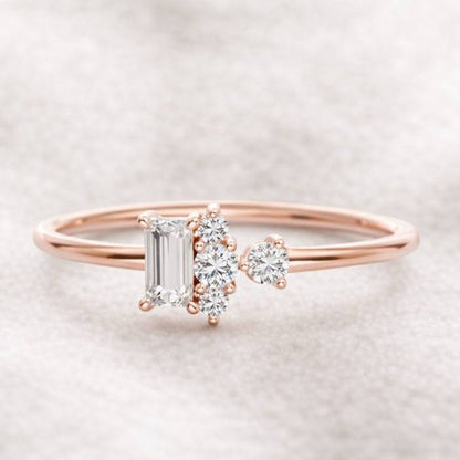 Rose gold ring with emerald-cut diamond and heart-shaped gemstone on a soft background