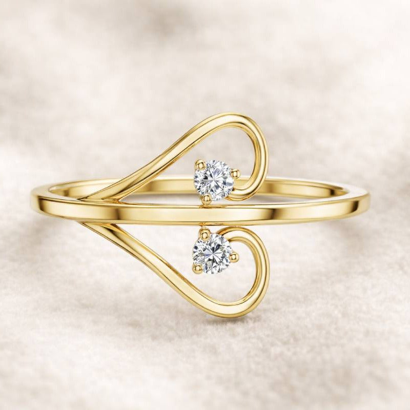 Gold ring with two diamonds on a beige background