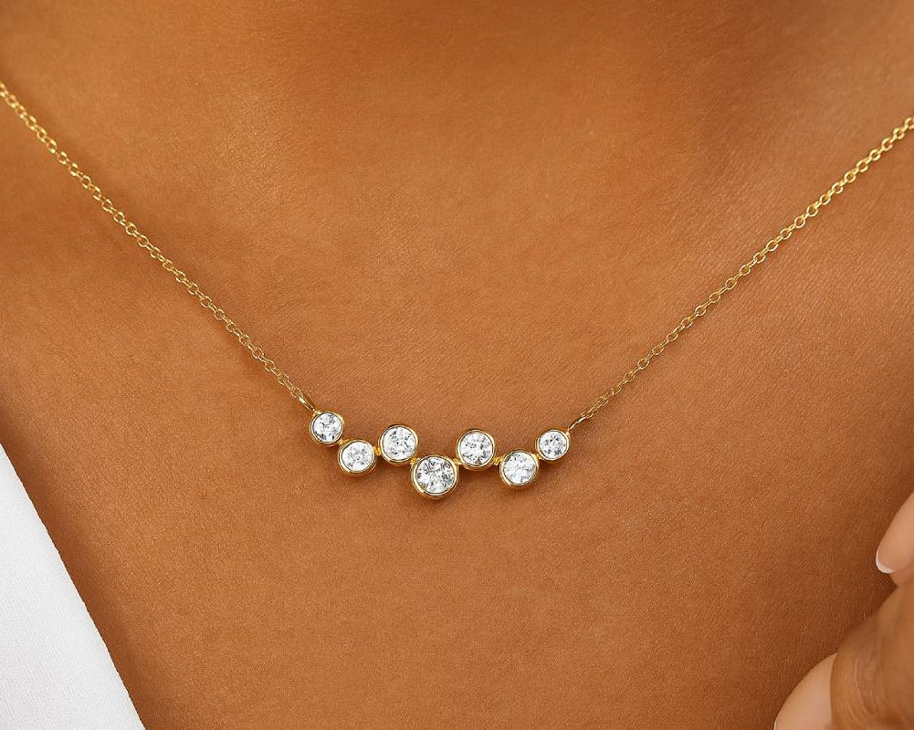 Gold necklace with small diamonds on a person's neck