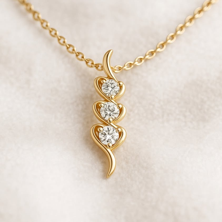 Gold necklace with a heart-shaped pendant on a light beige background