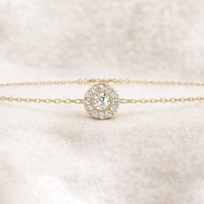 Gold bracelet with a diamond on a soft beige background