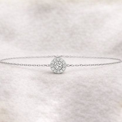 bracelet with a round diamond charm on a light fabric background