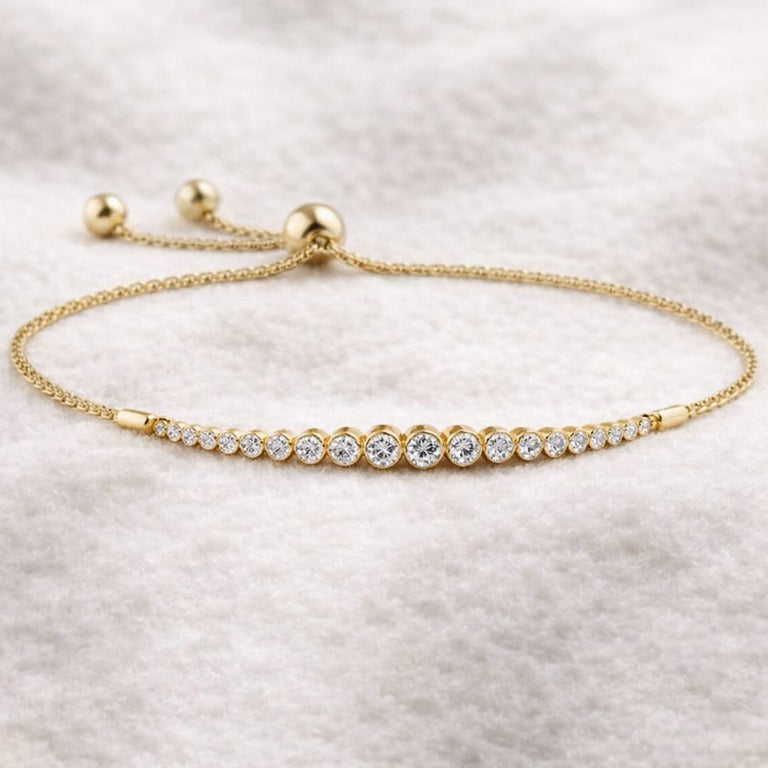 Gold bracelet with clear stones on a light gray background