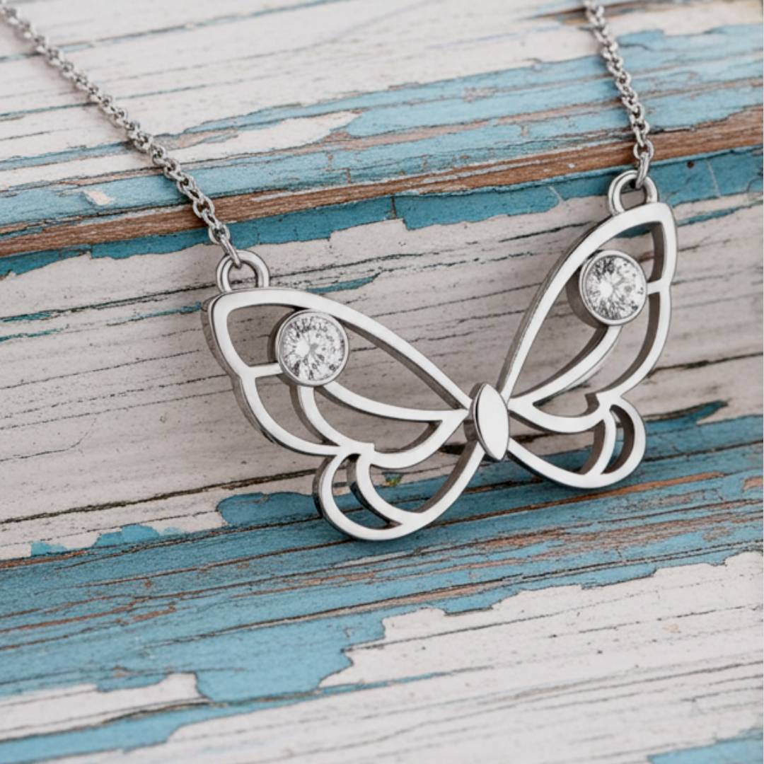 butterfly necklace with gemstones on a wooden surface