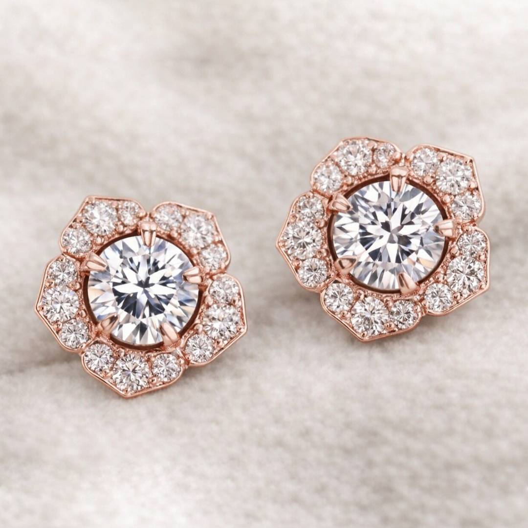 Rose gold earrings with large central gemstones and smaller stones on a light background