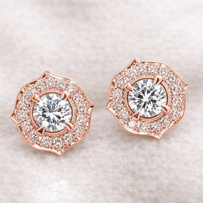 Rose gold earrings with clear gemstones on a light background