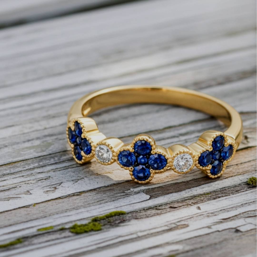 Gold ring with blue gemstones and diamonds on a wooden surface