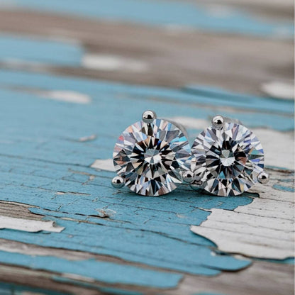 Pair of stud earrings with large gemstones on a rustic wooden surface.