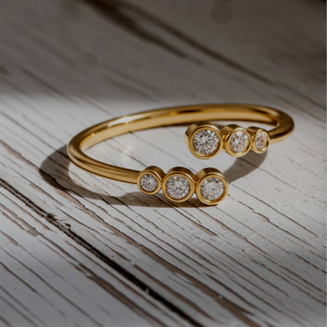 Gold ring with embedded diamonds on a wooden surface