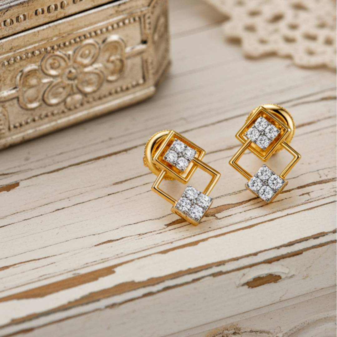 Gold earrings with diamond accents on a wooden surface