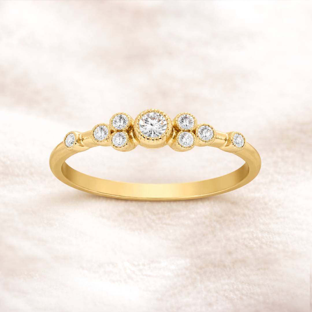 Gold ring with diamonds on a soft pink background