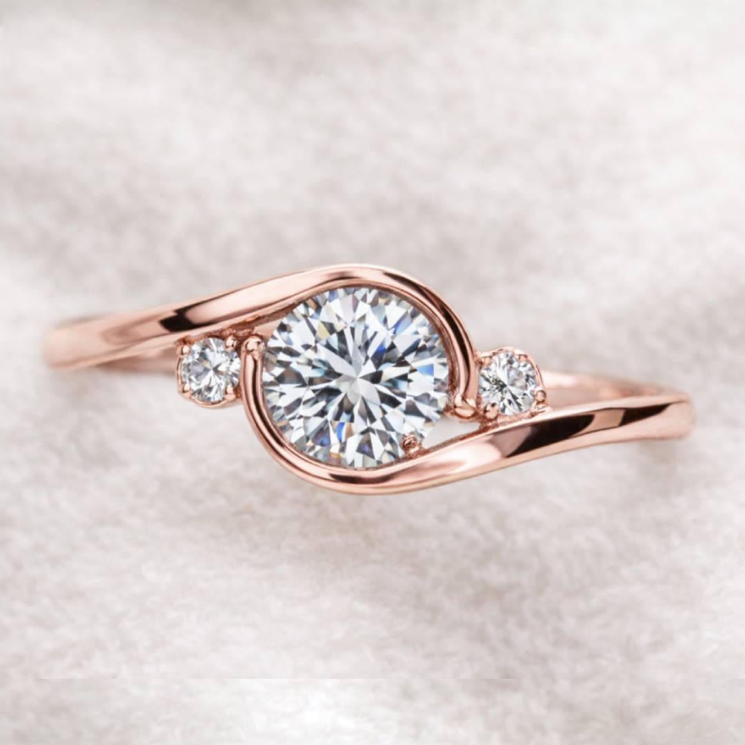 Rose gold ring with a large diamond and smaller diamonds on a soft white background