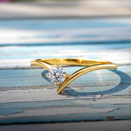 Gold ring with a diamond on a wooden surface