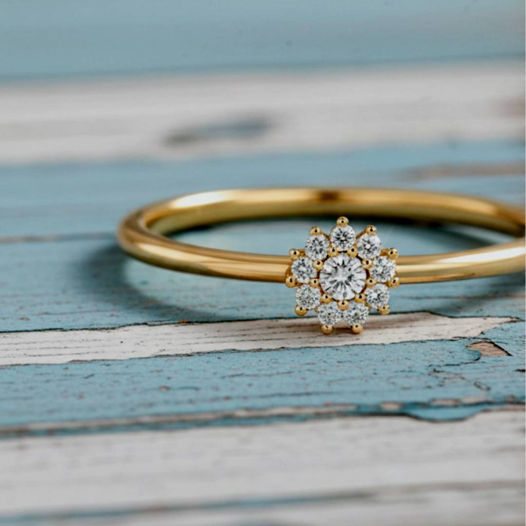 Gold ring with a diamond flower clasp on a wooden surface
