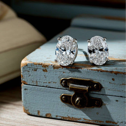 Diamond earrings on a rustic wooden box with a blurred background