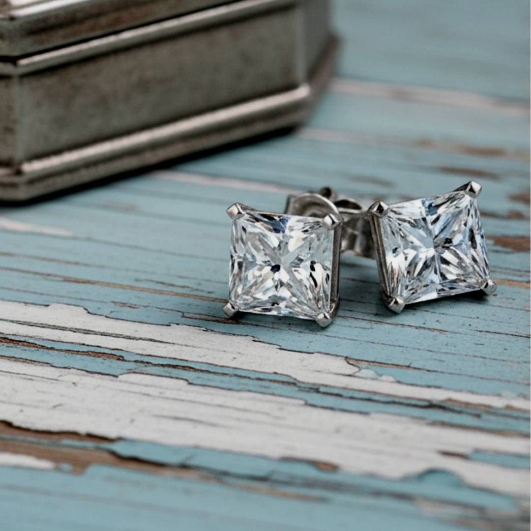 Pair of square-cut stud earrings on a rustic wooden surface