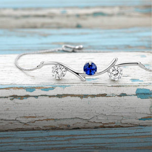 A delicate gold bracelet that combines a natural blue sapphire and two round diamonds. The bracelet is made of 14 karat gold.