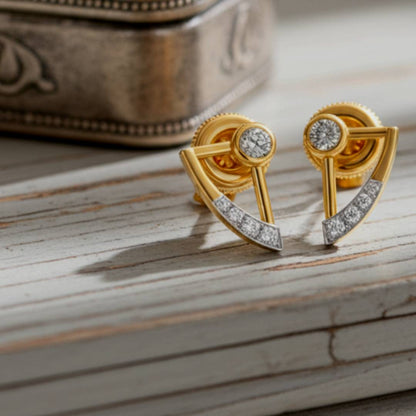 Gold earrings with diamond accents on a wooden surface