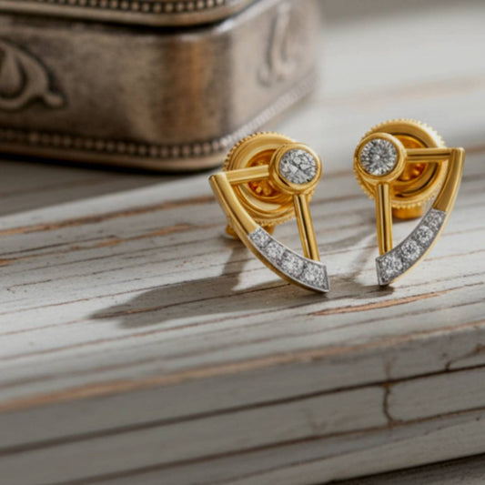 Gold earrings with diamond accents on a wooden surface