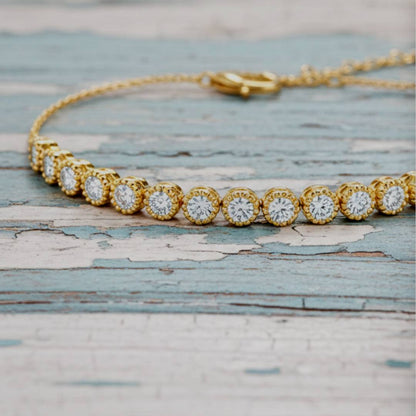 Gold bracelet with diamond accents on a textured wooden surface