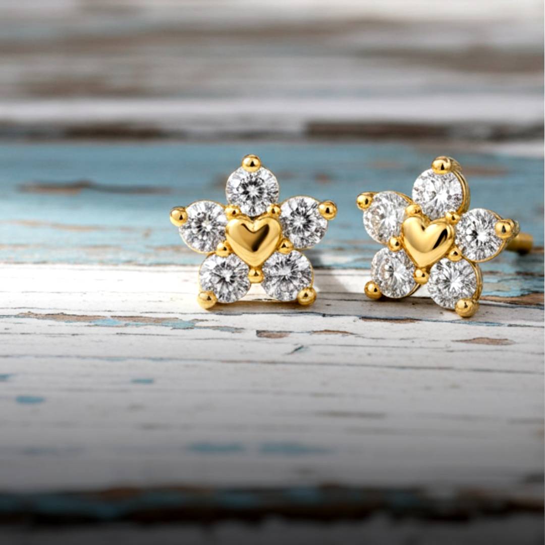 Gold and diamond earrings on a wooden surface