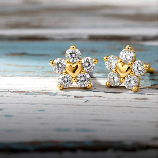 Gold and diamond earrings on a wooden surface