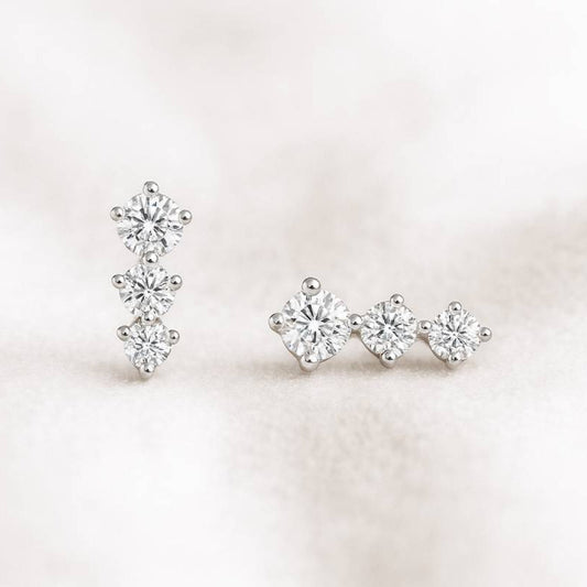 Pair of earrings with clear gemstones on a light pink background